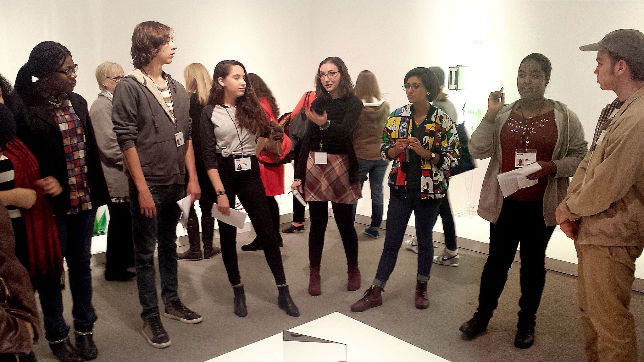 students stand around and discuss art