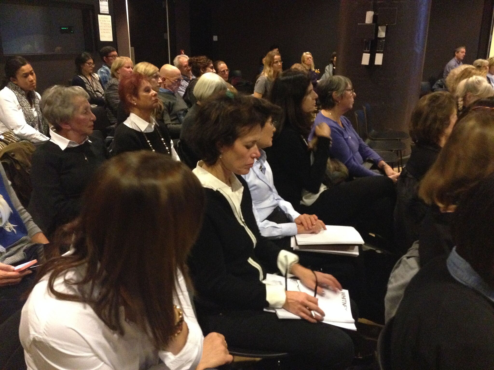 People sitting in an audience listening to a talk.