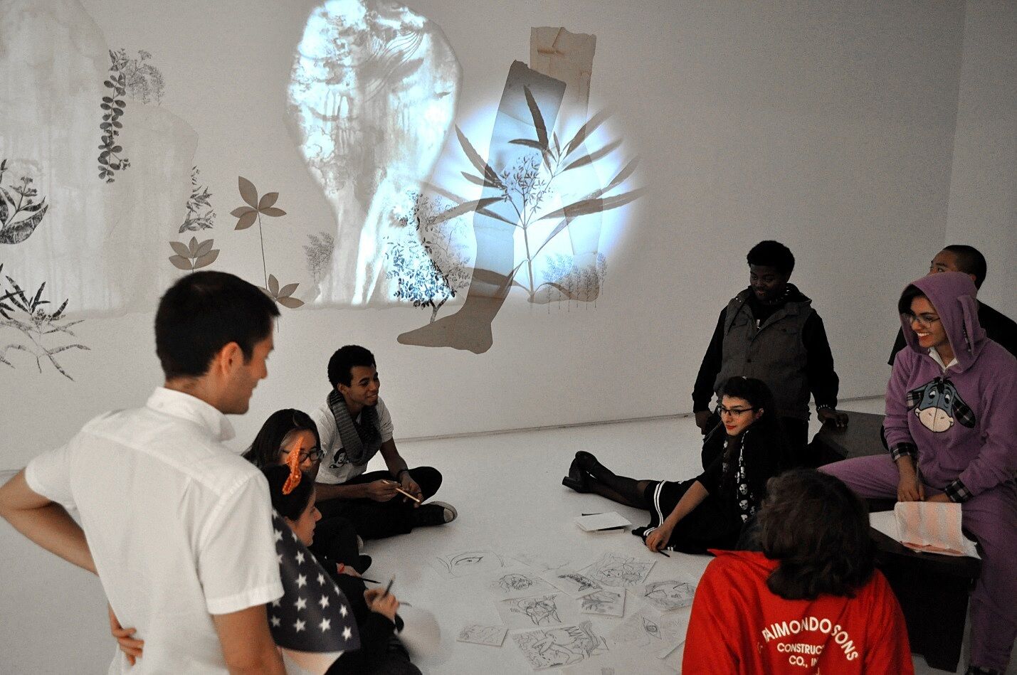 Students sitting on ground in gallery