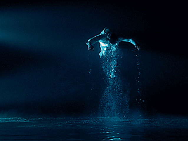 A video still of a figure jumping out of water.