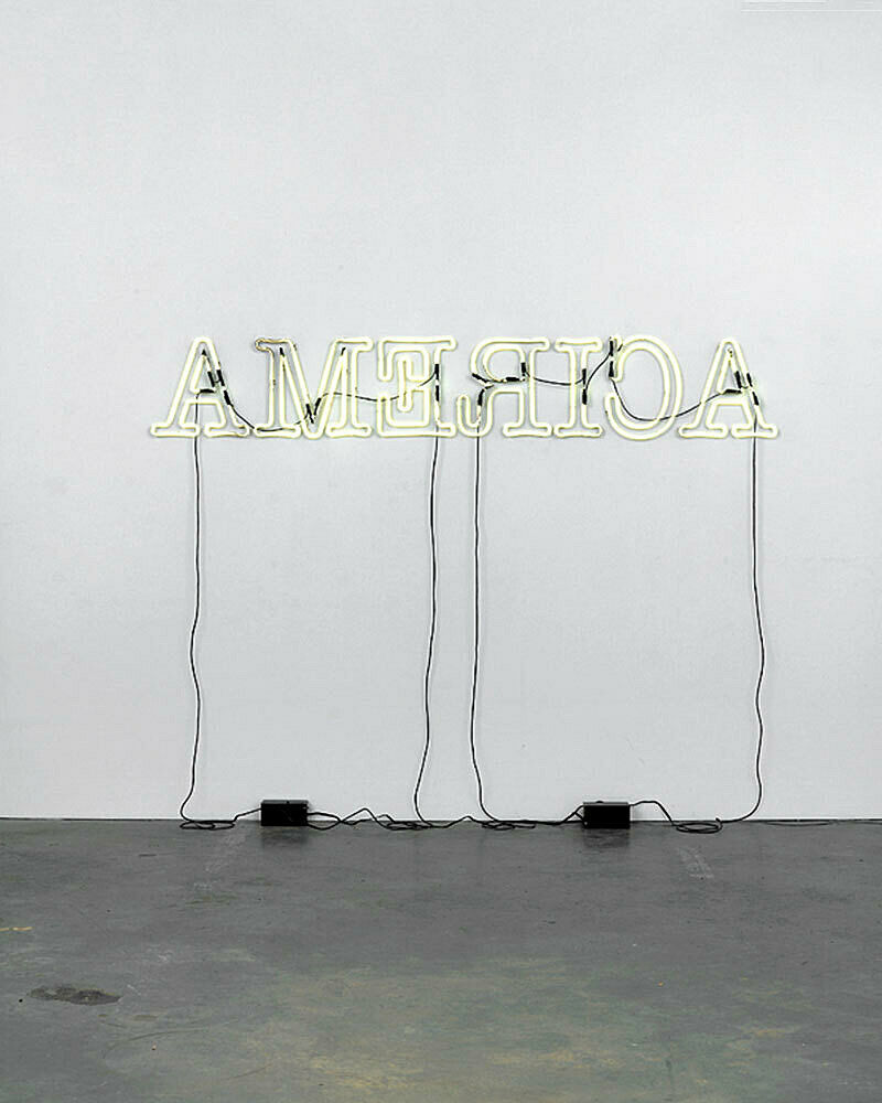 A light installation that reads "America" with backwards letters.