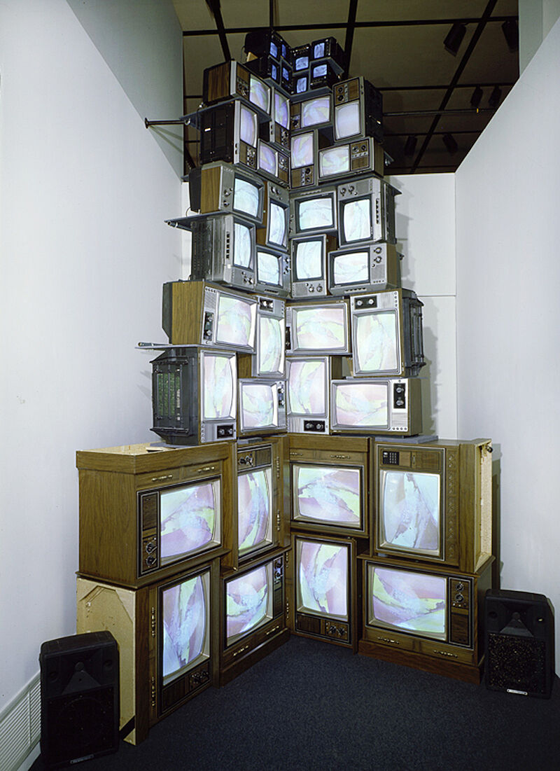 A sculpture of televisions stacked up to the ceiling.