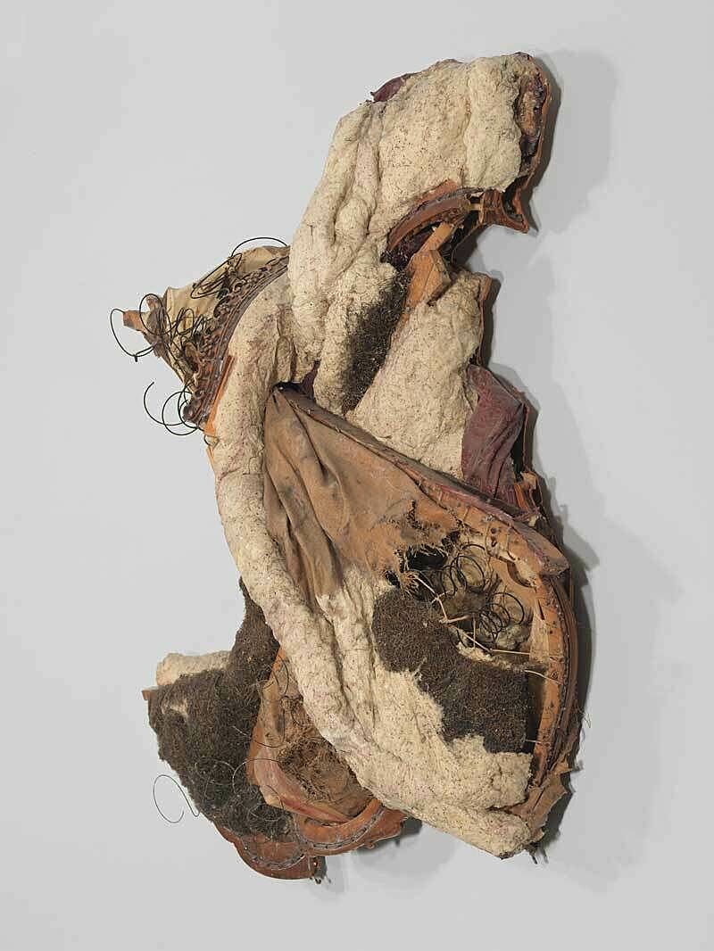 A sculpture with various materials on a wall.