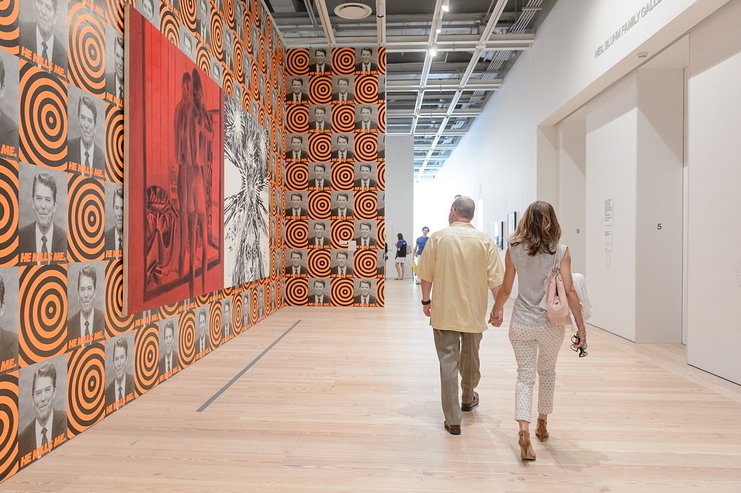 Two adults walks through a gallery during the event.
