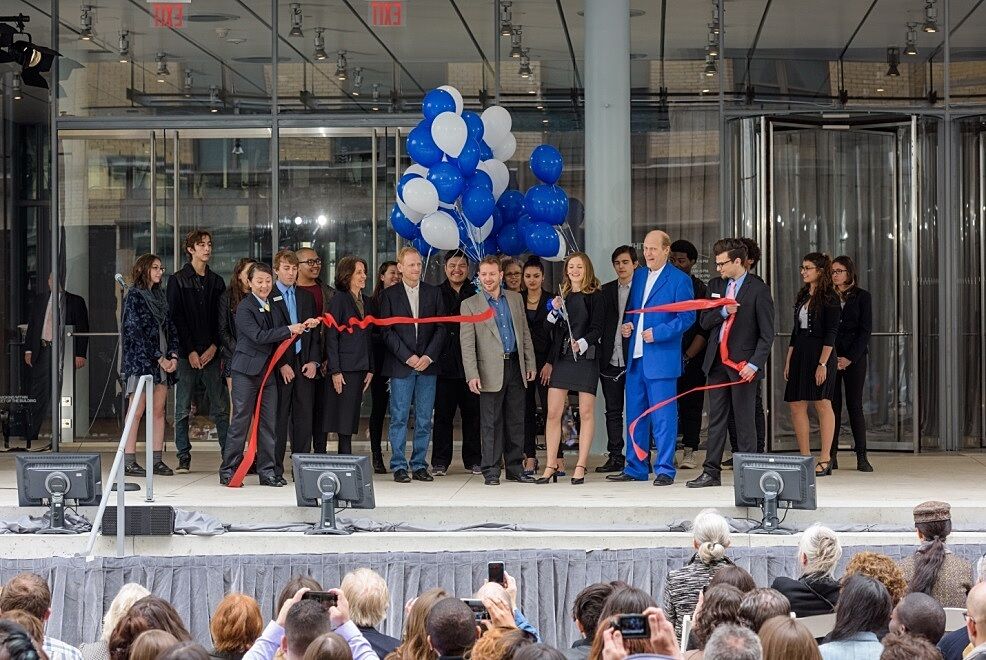 Youth leaders from the museum help cut a ribbon in front of the new Whitney building.