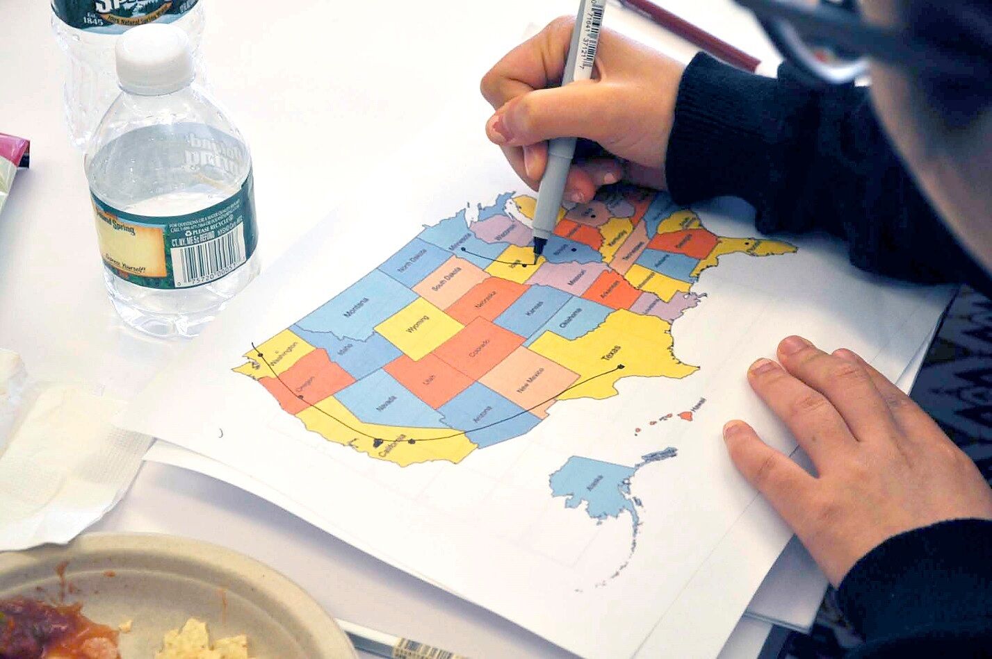 teen writing on a map