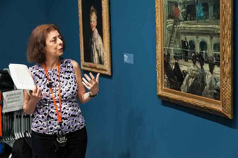 A person giving a talk in a gallery.