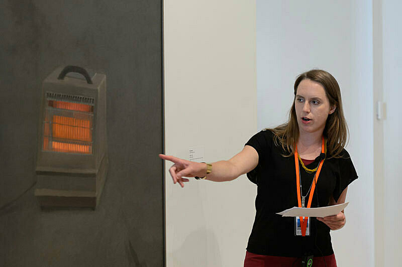 A person discussing artwork in a gallery.