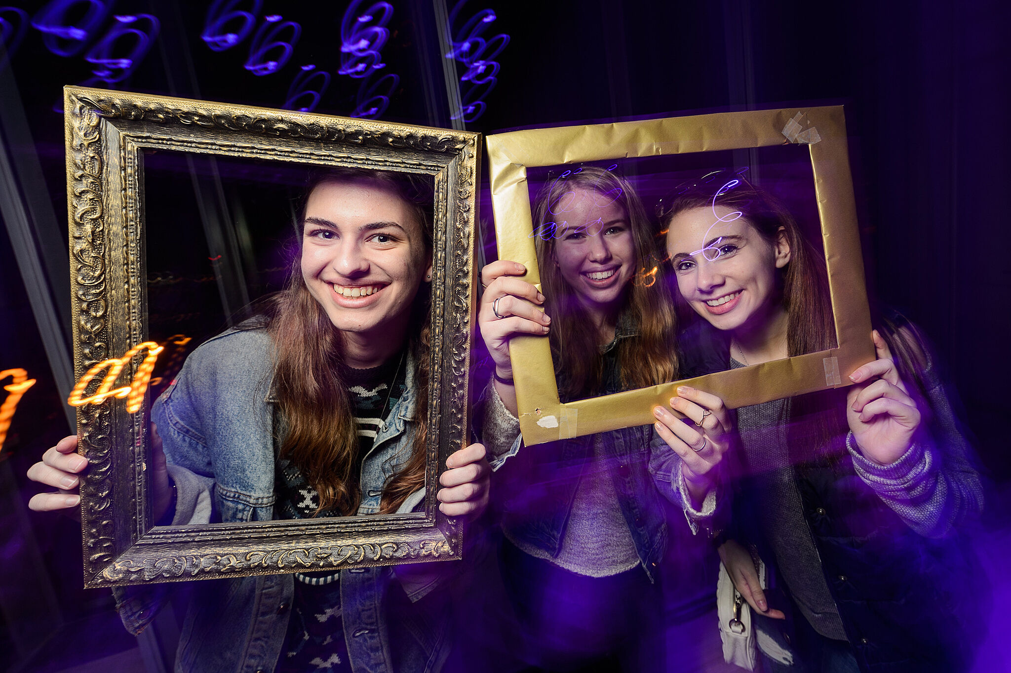 Teens pose with frames around their faces.