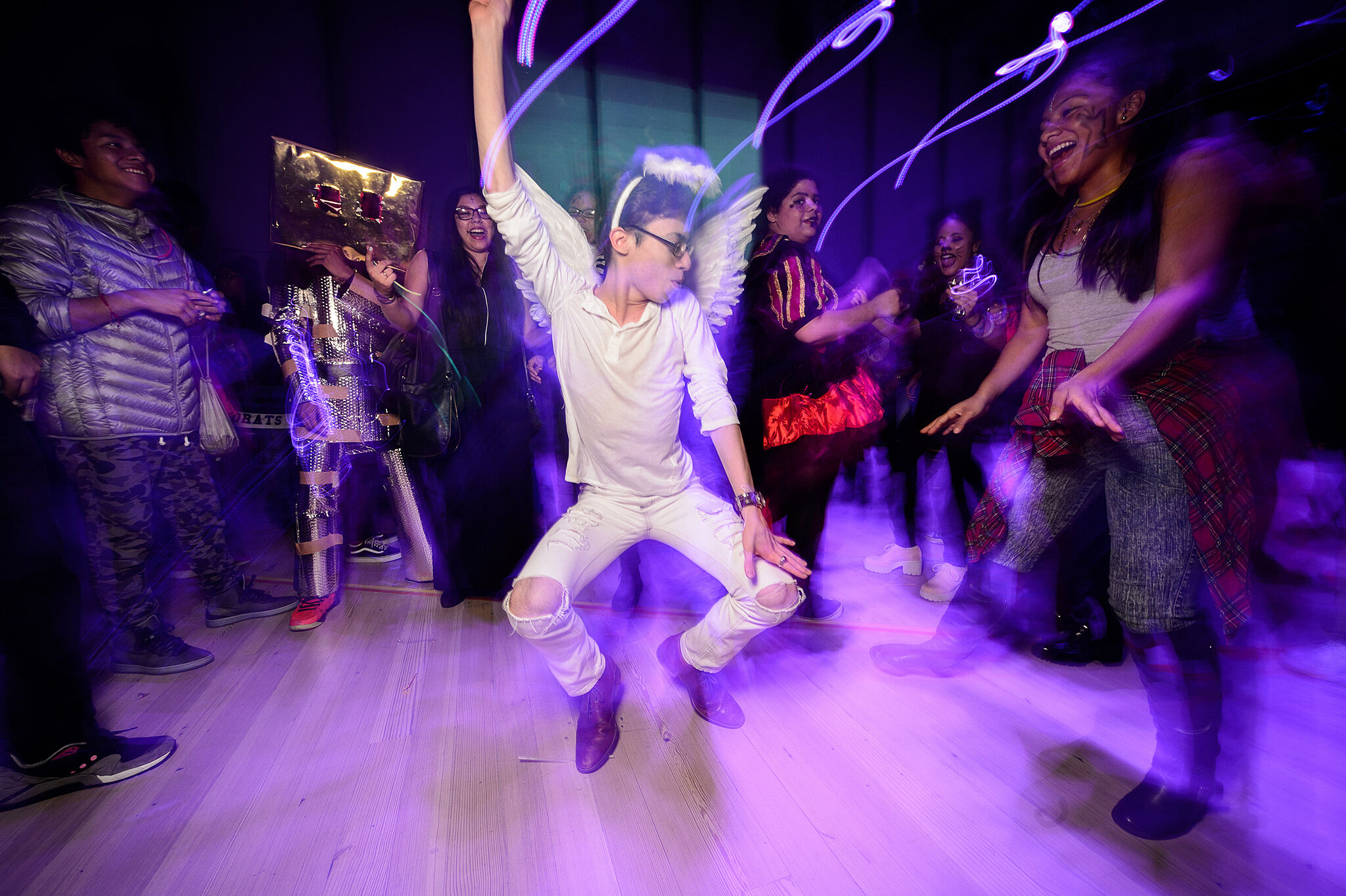 A teen dressed up as an angel dances for the crowd.