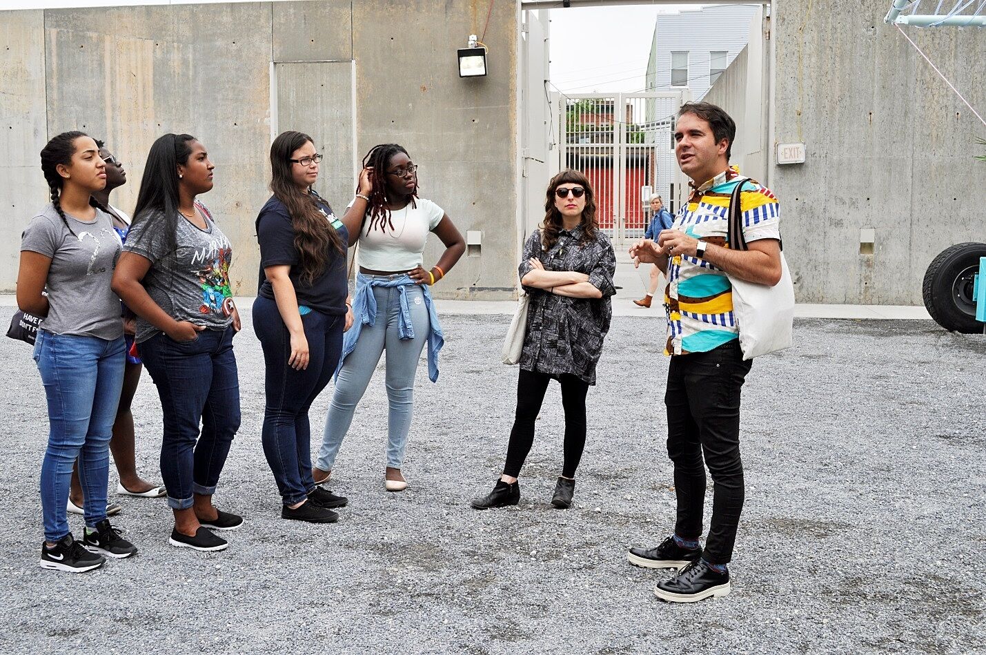 artist talks outside to group of teens