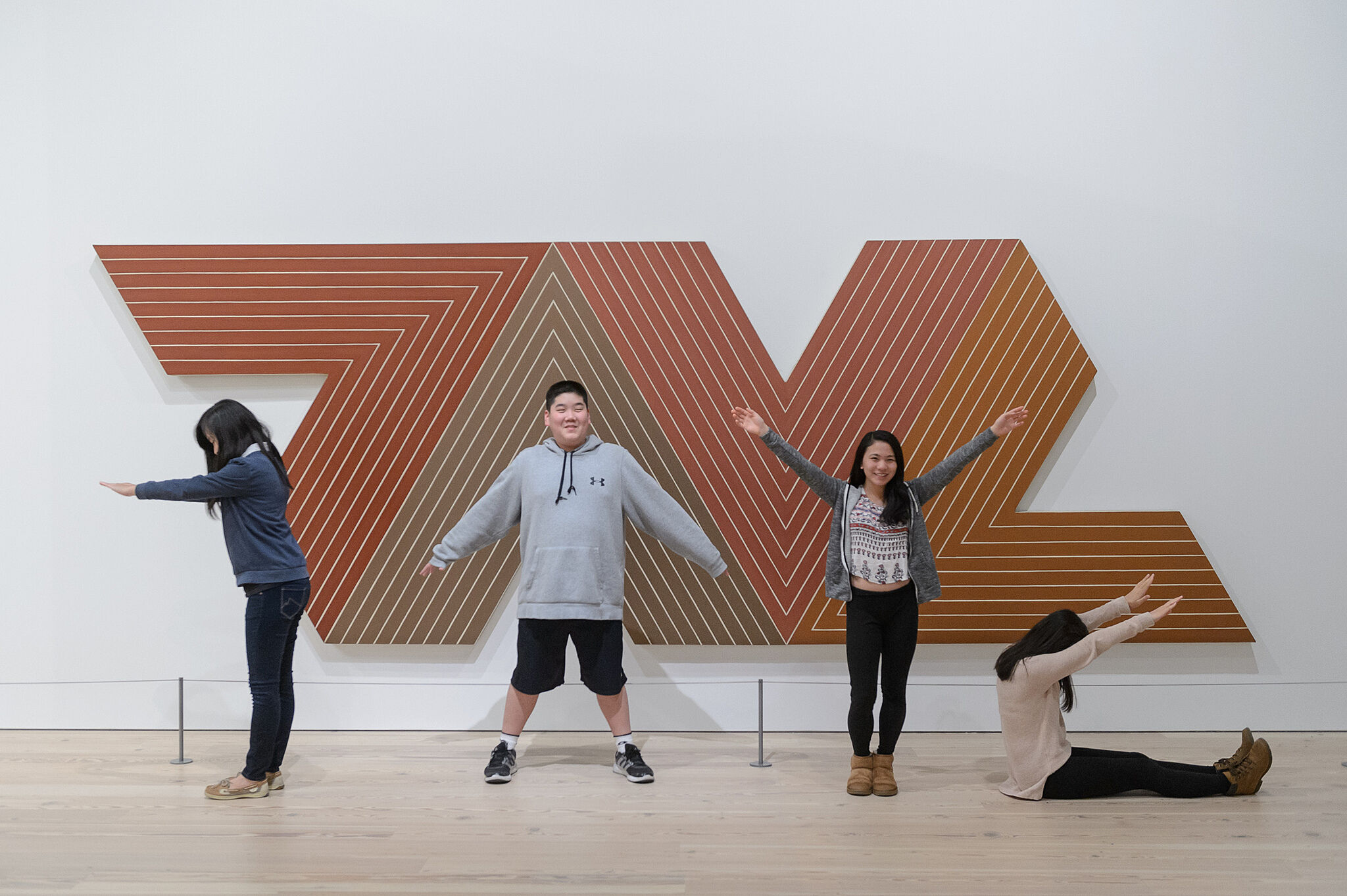 Kids posing in front of a Frank Stella piece.