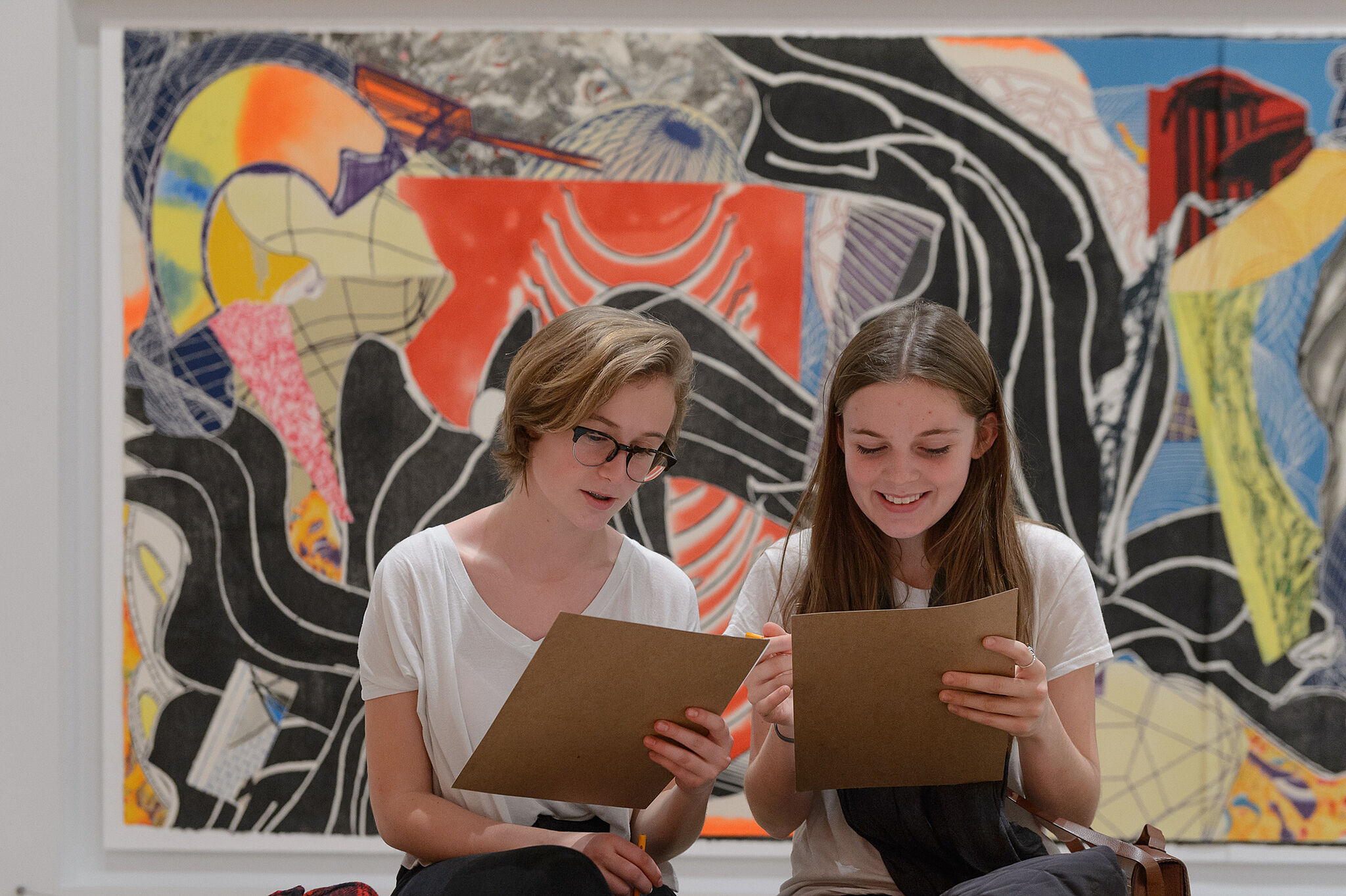 Two girls work on an art project in the Frank Stella exhibition.