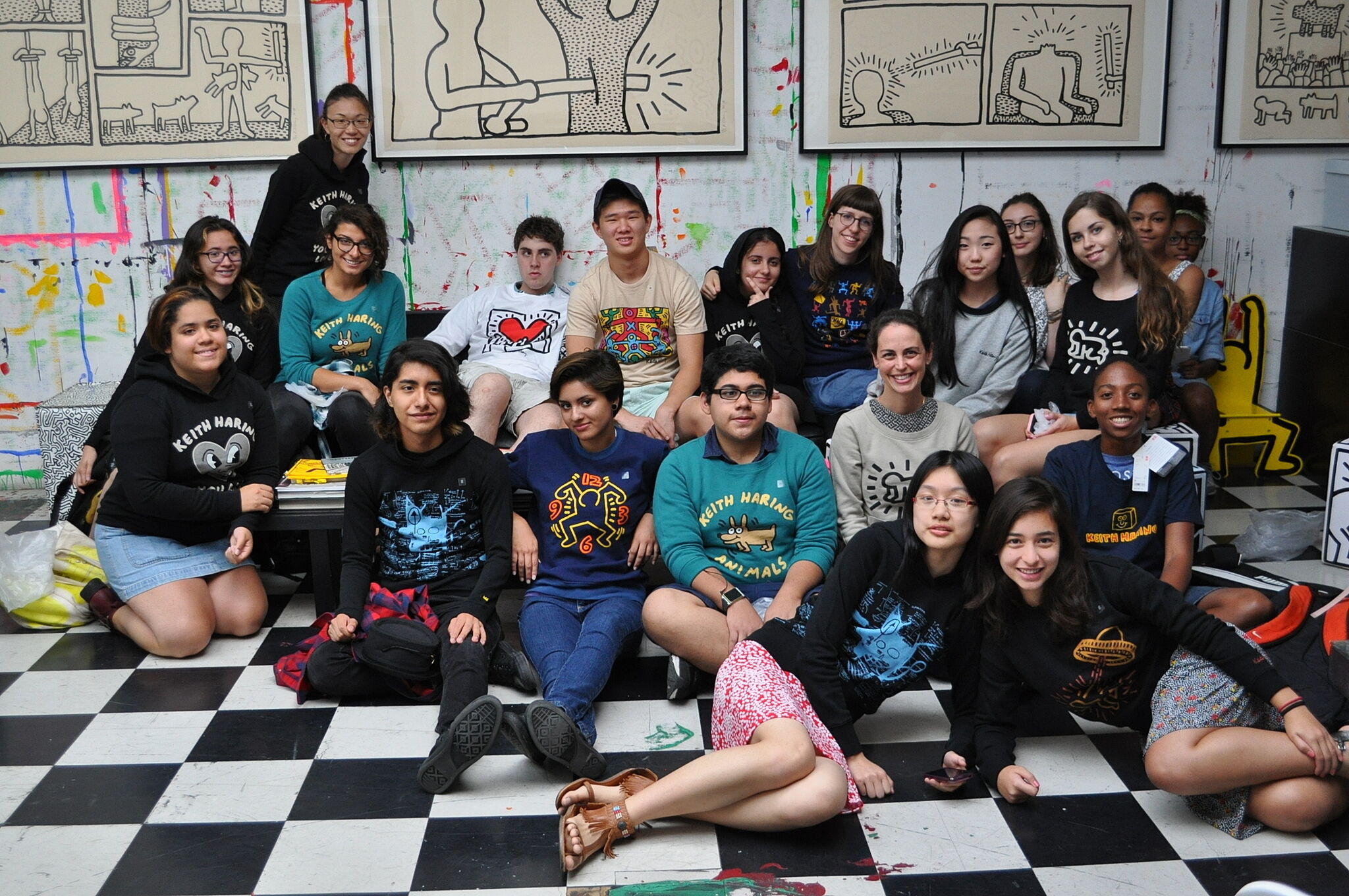 teens sit and pose in front of artwork