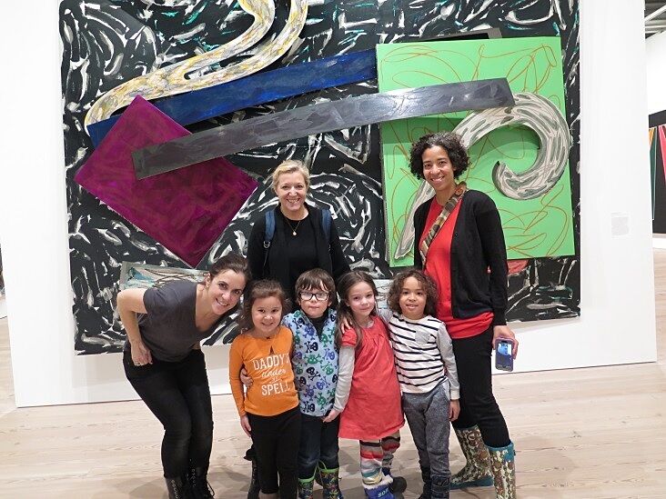 A family posing in front of a Frank Stella 
