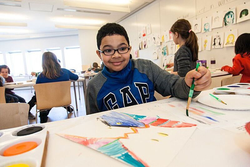A child painting his project during art camp
