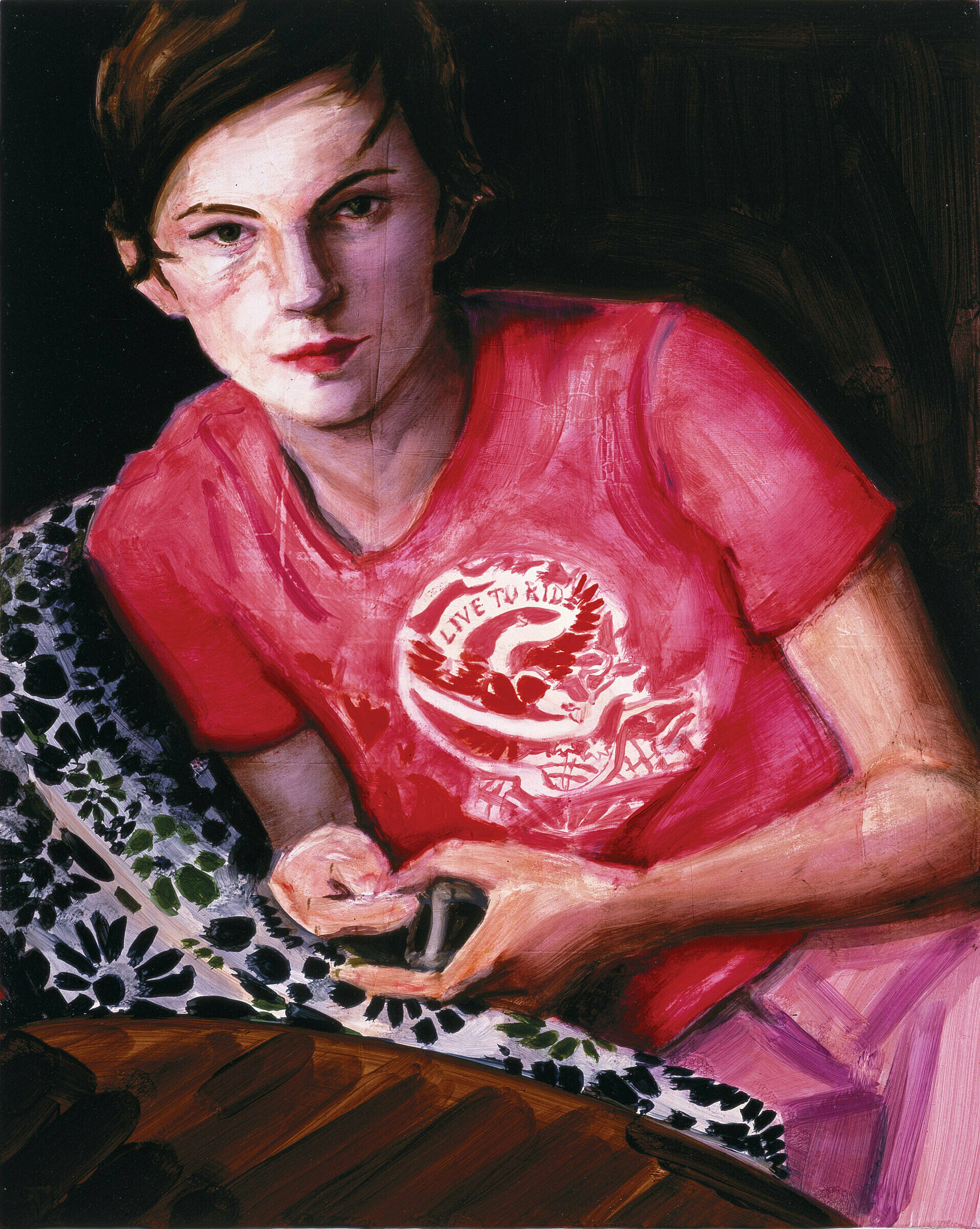 A work by Elizabeth Peyton. A figure in a red teeshirt reclines on a chair. The shirt reads, 'Live to Ride'