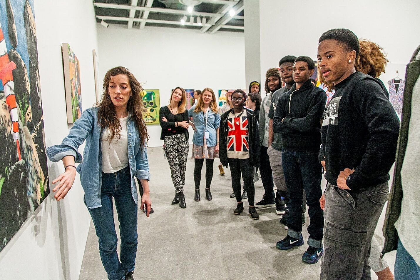 Artist Jamian Juliano-Villani shows off her work to students in the gallery.