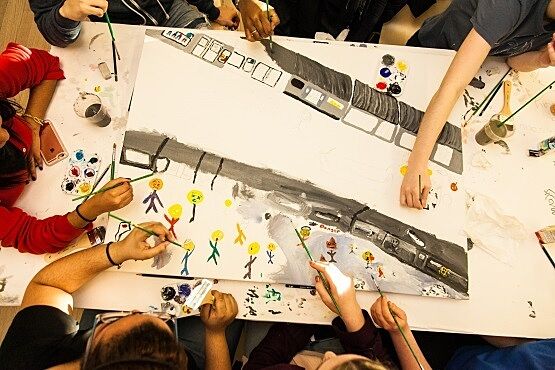 An overhead view of a subway painting by students.