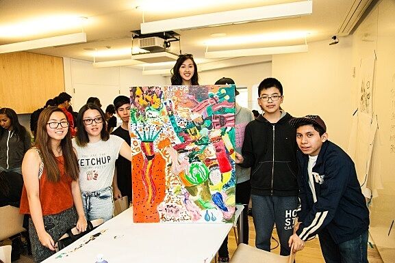 A group of teens shows off their final painting project.