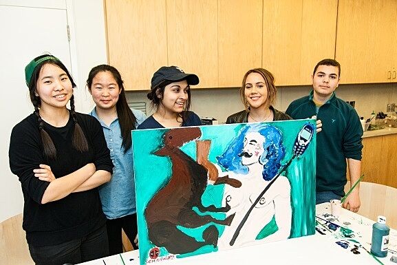 A student group displays their final artwork of a horse and man with blue hair.