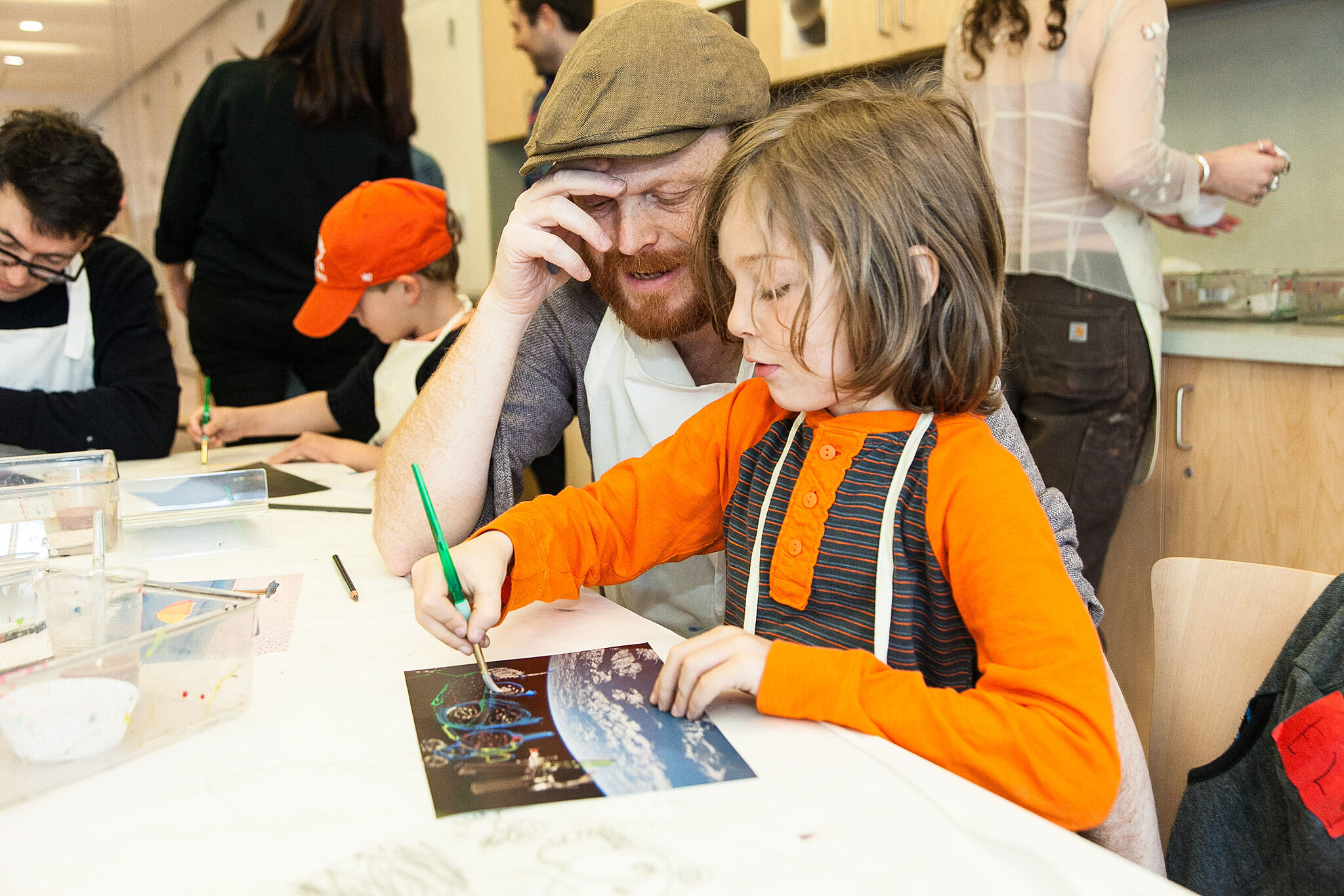 A father and child work on a painting together