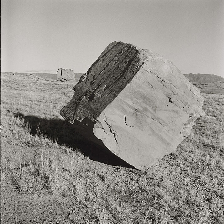 A photograph of a massive rock in the desert.