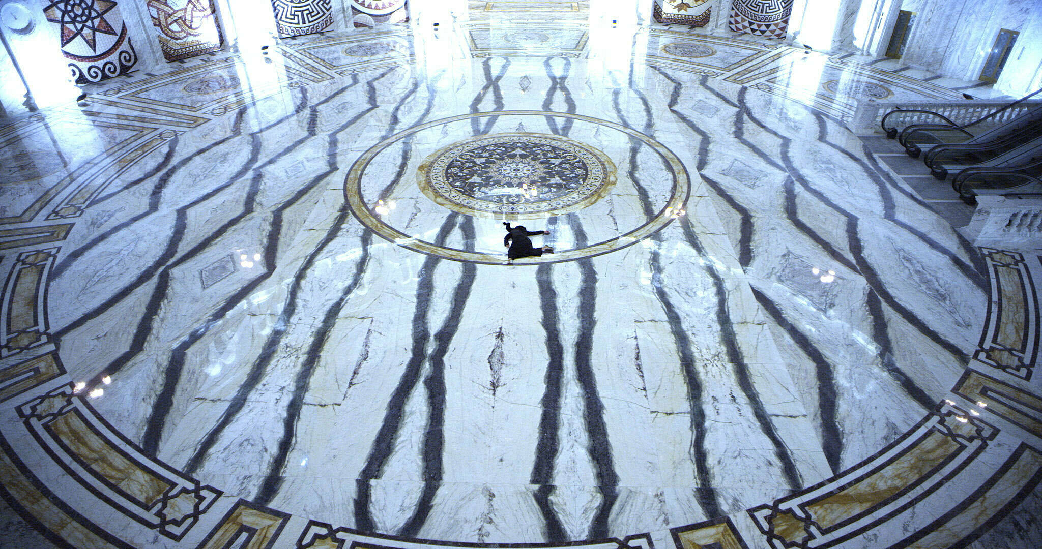 A woman in black sprawled on a marble floor