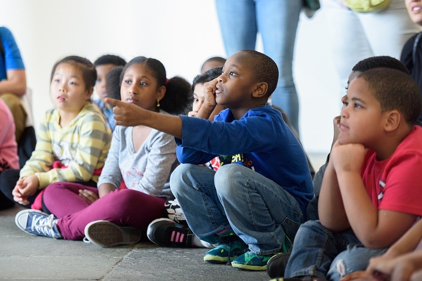 students sitting and listening and pointing