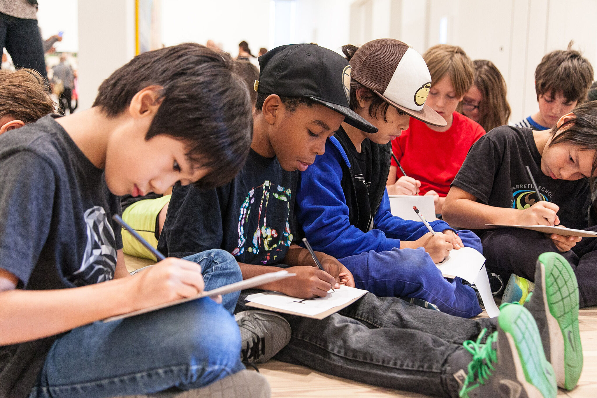 Young students sitting and writing on their notebooks