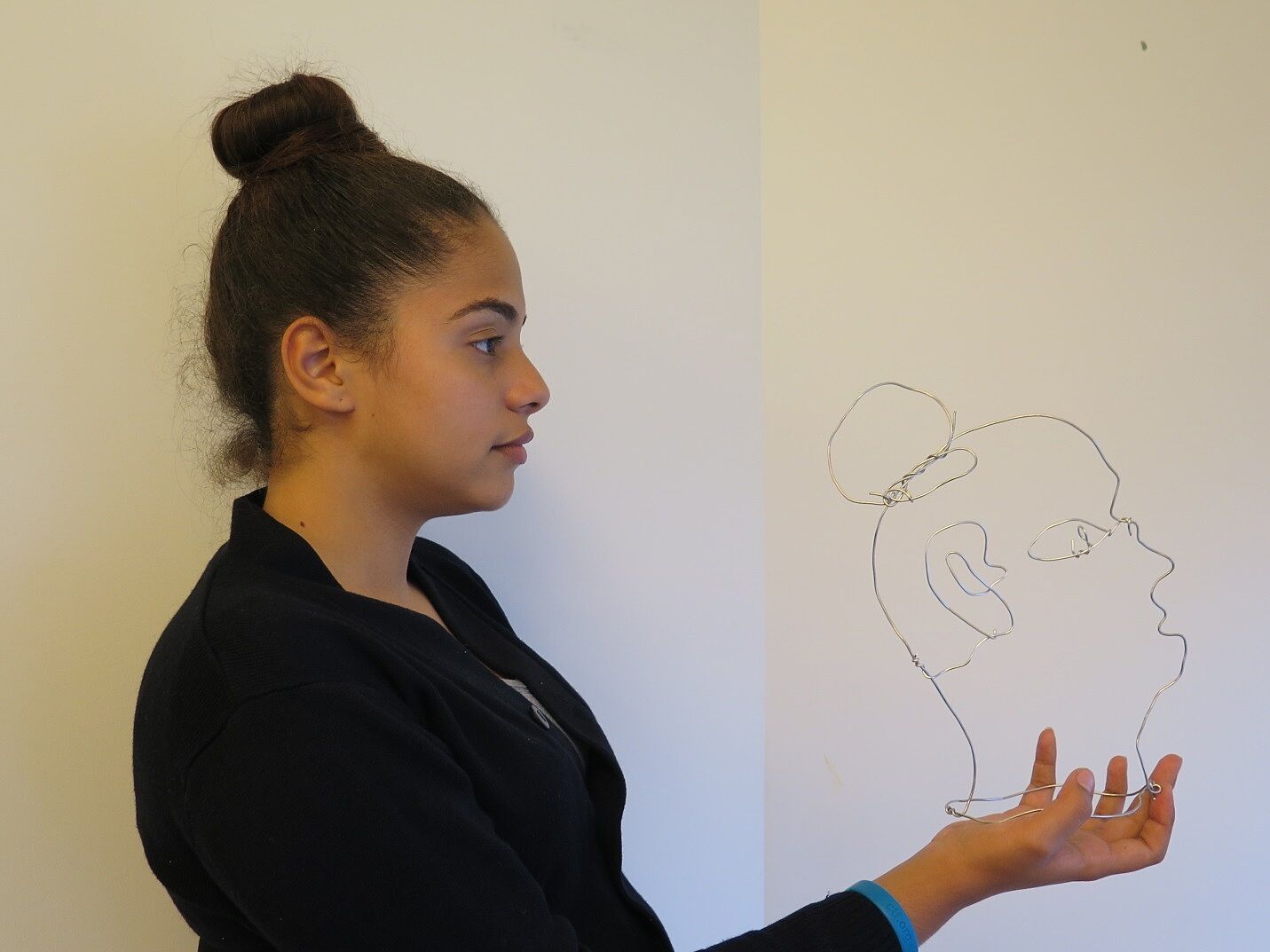 A young artist models her portrait at Open Studios.
