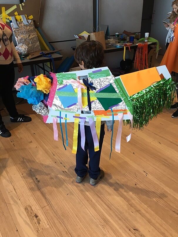 A boy shows off the wings of his costume