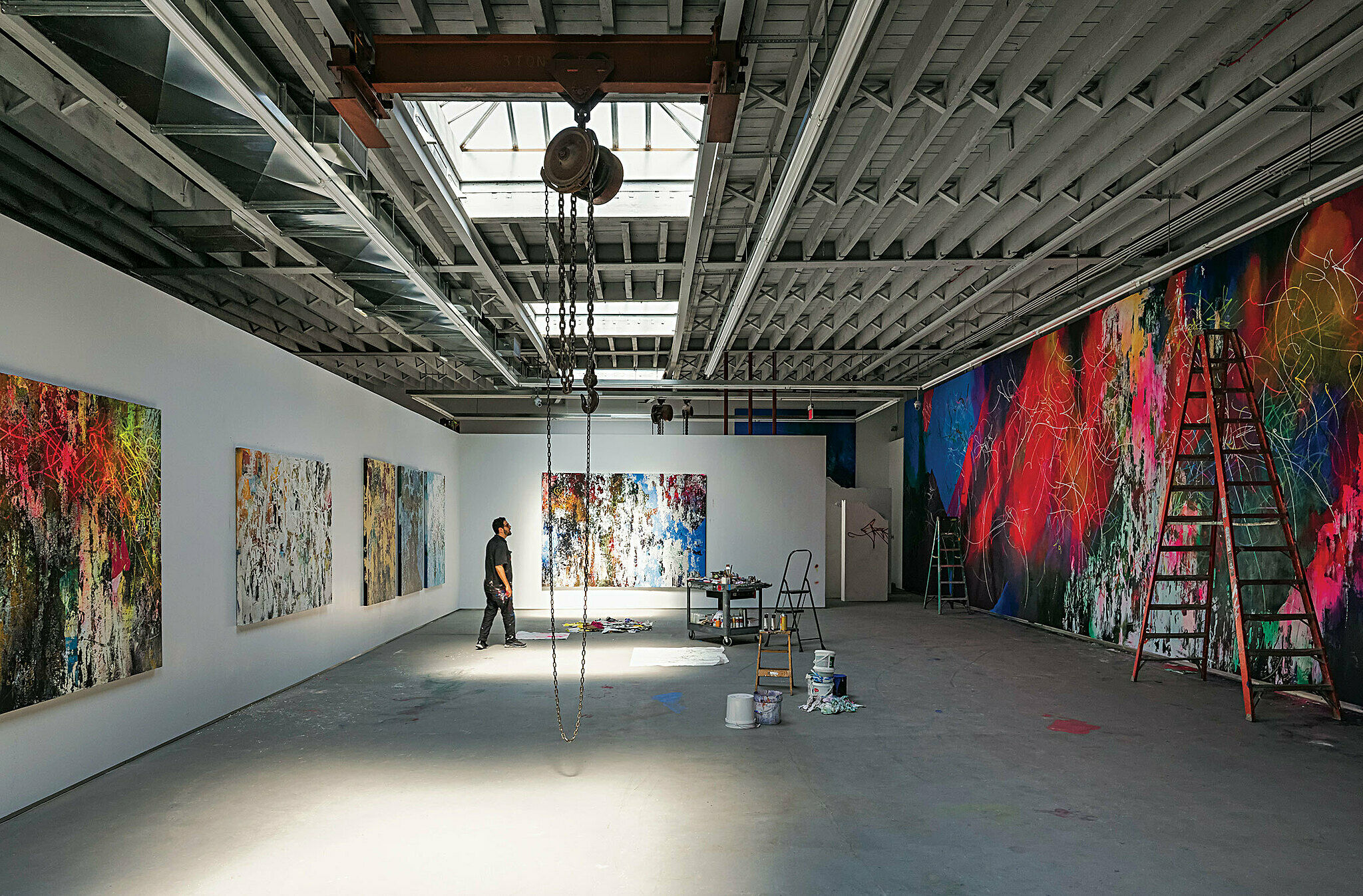 Large industrial studio with bright paintings on wall