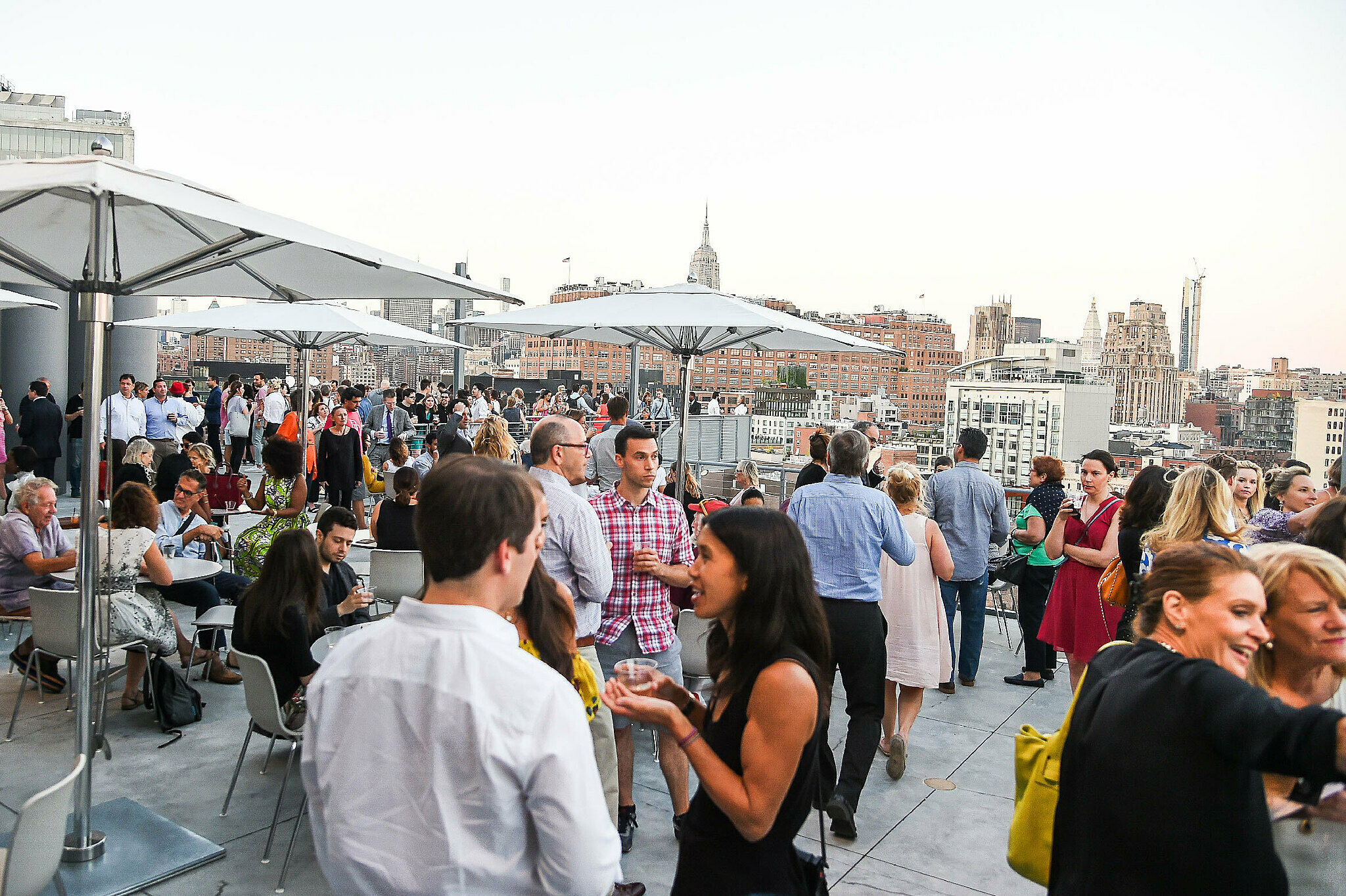 A crowd gathers on the Whitney Museum's eighth-floor terrace in view of the Hudson river