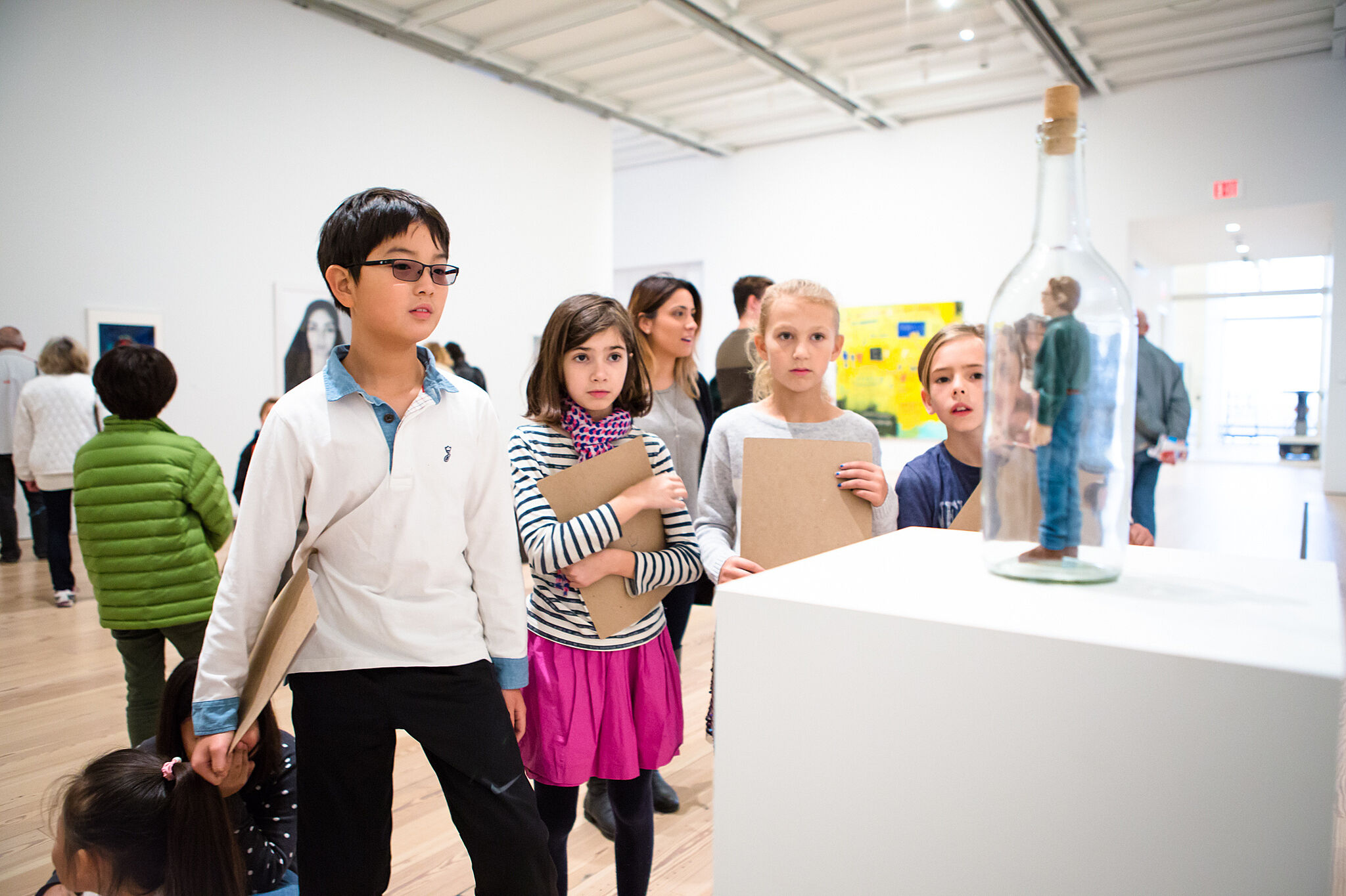 students look at statue in gallery