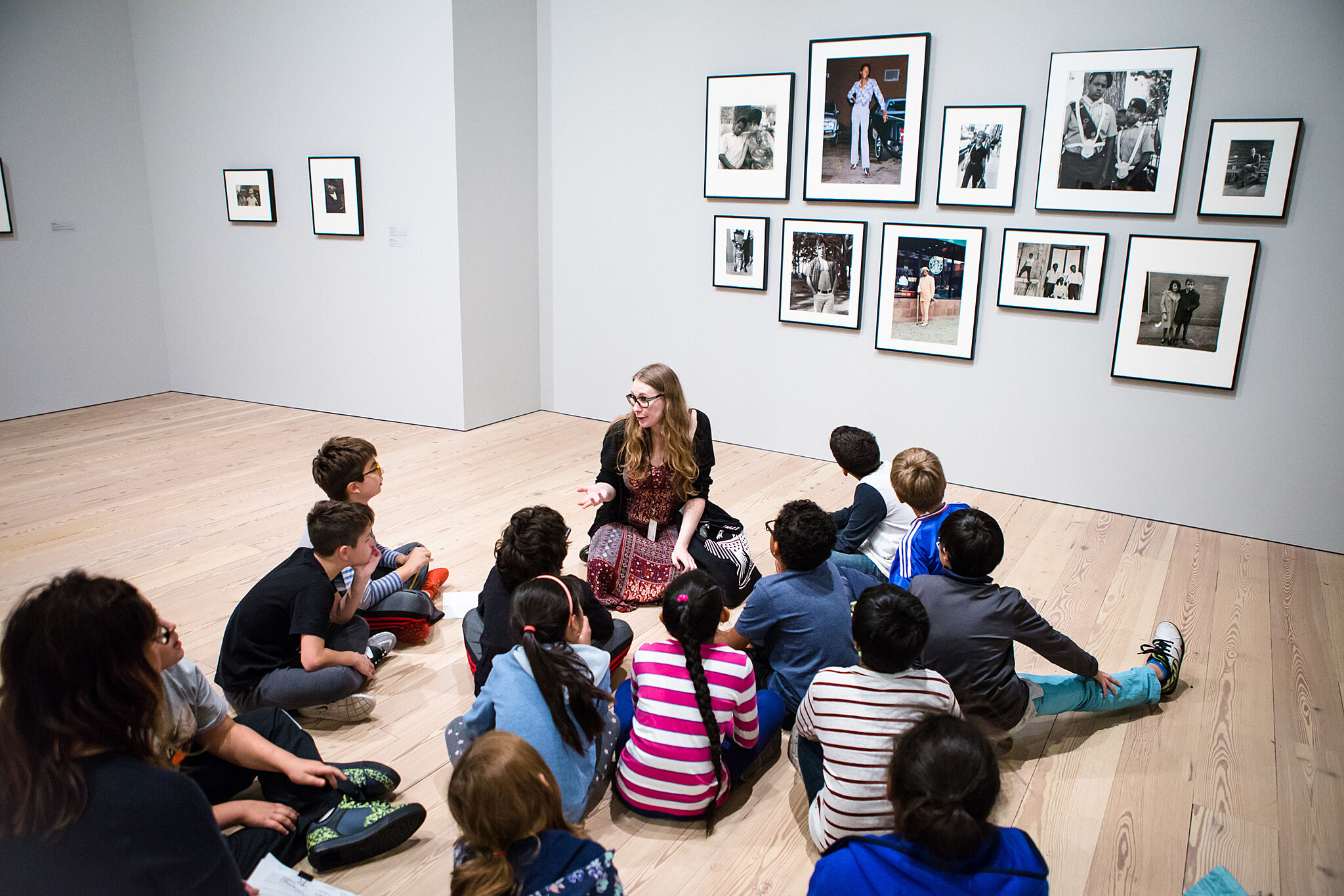 students sitting looking at paintings on wall