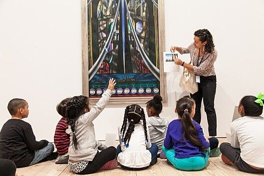 students sitting in front of bridge painting