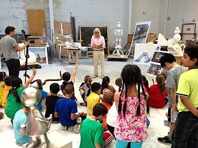 students sit in studio around artist