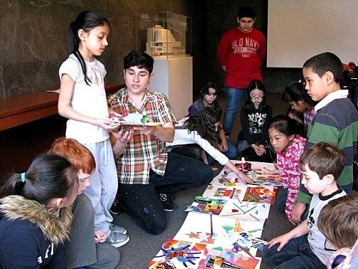 children standing showing art to students