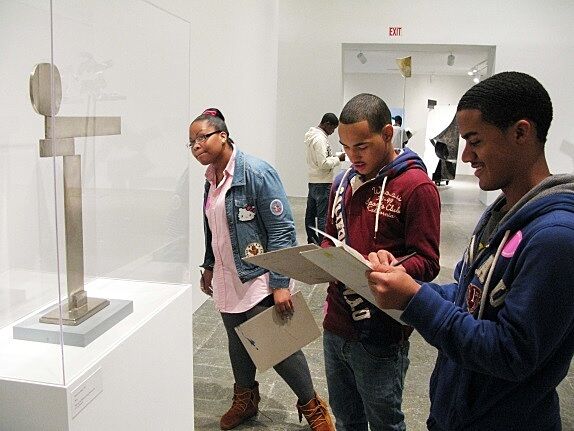 kids looking at sculpture and taking notes