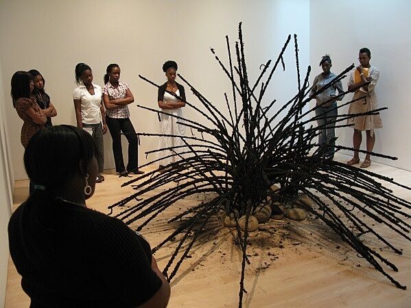 black installation in middle of room with students