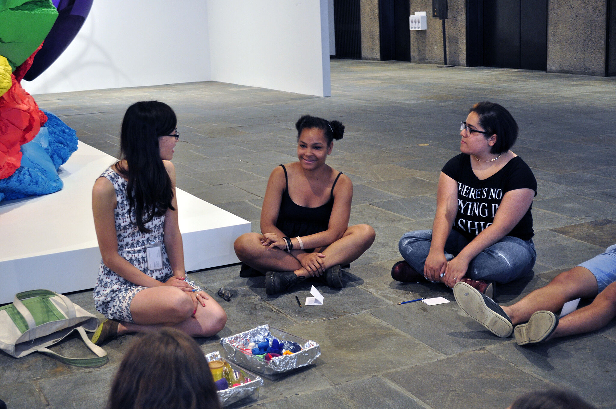Teens in discussion on the floor.