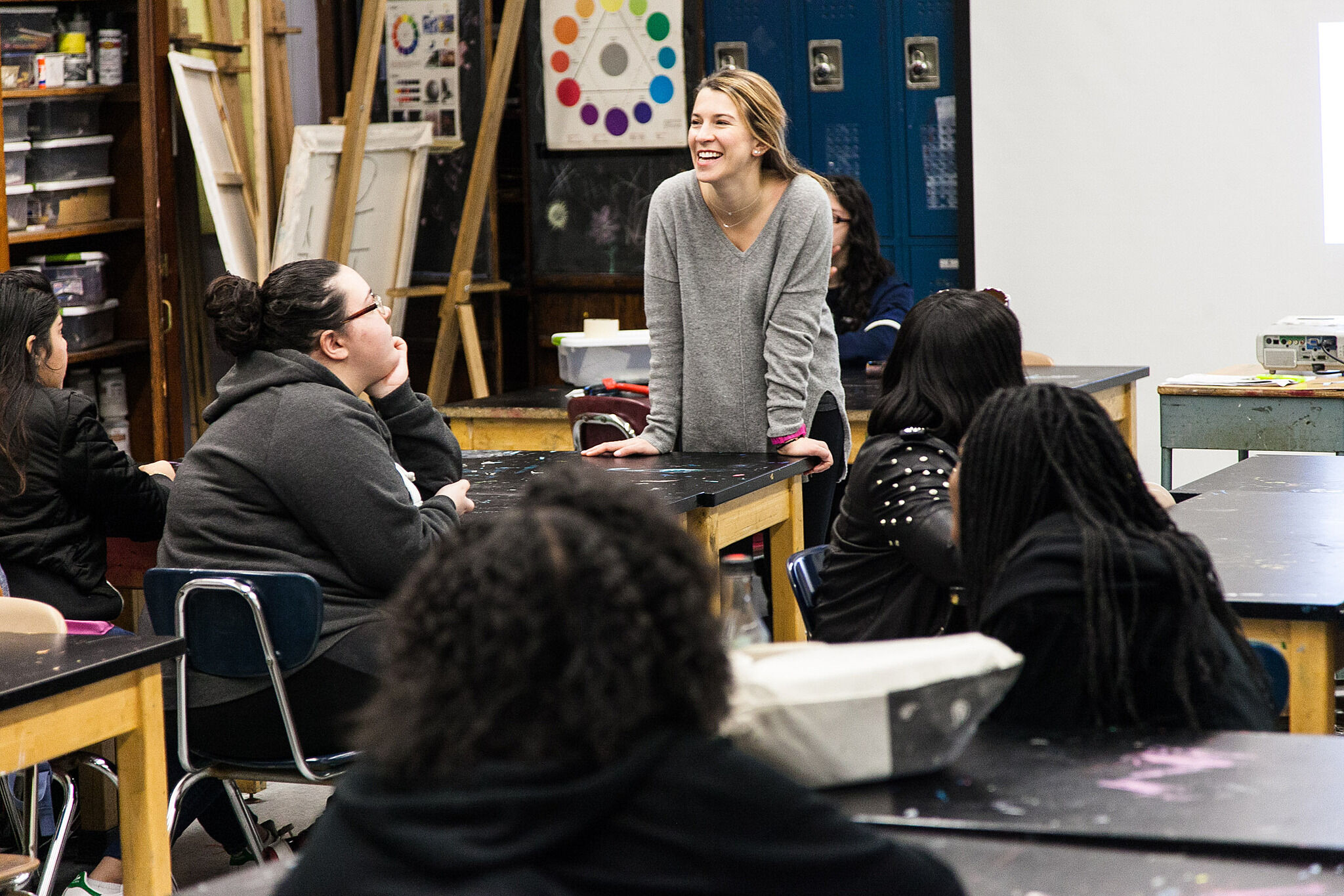 Educator stands discussing with three students.