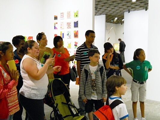 Students and families standing in gallery.