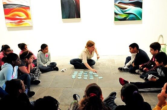 Students look at post it notes laid out by educator.