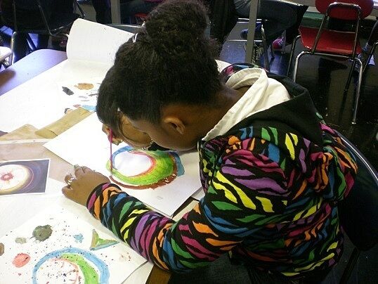 Student intently focused on her watercolor painting.