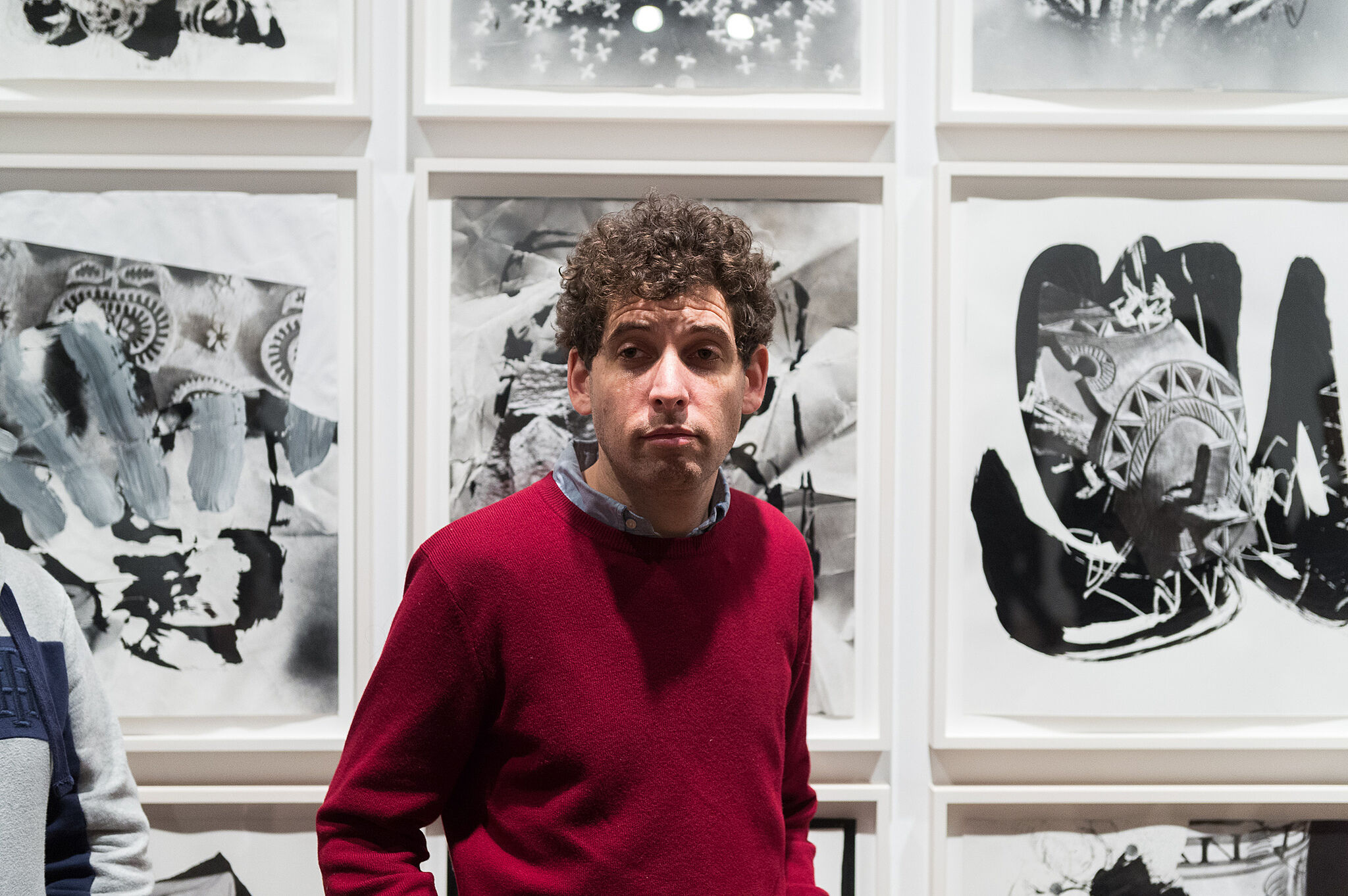 The artist Darren Bader stands next to art work from the Biennial exhibit.