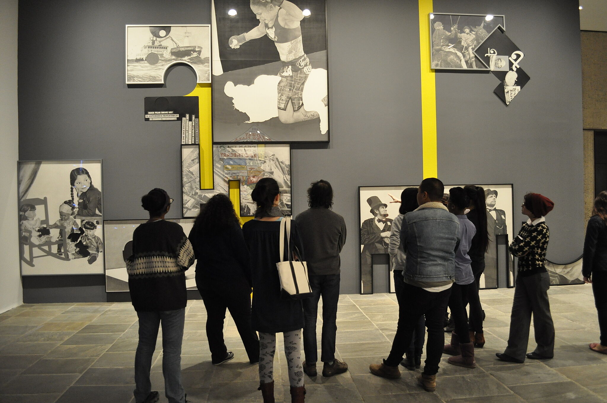 A youth group looks at large photos in the Biennial exhibit. 