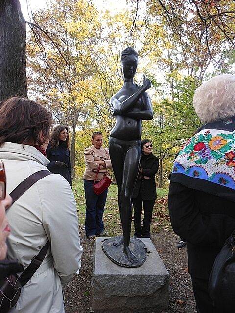 Sculpture of a woman in underwear with onlookers around.