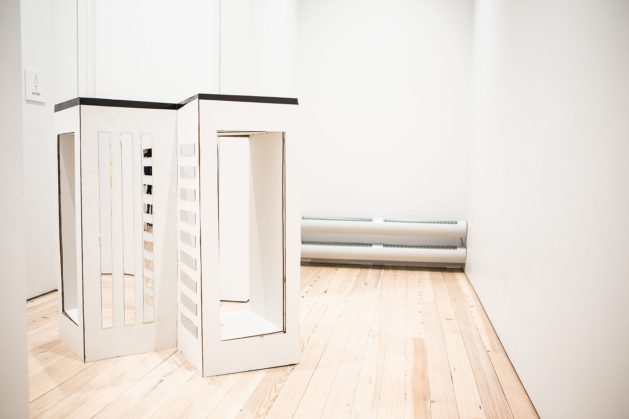 Photo of tall boxes in a gallery.